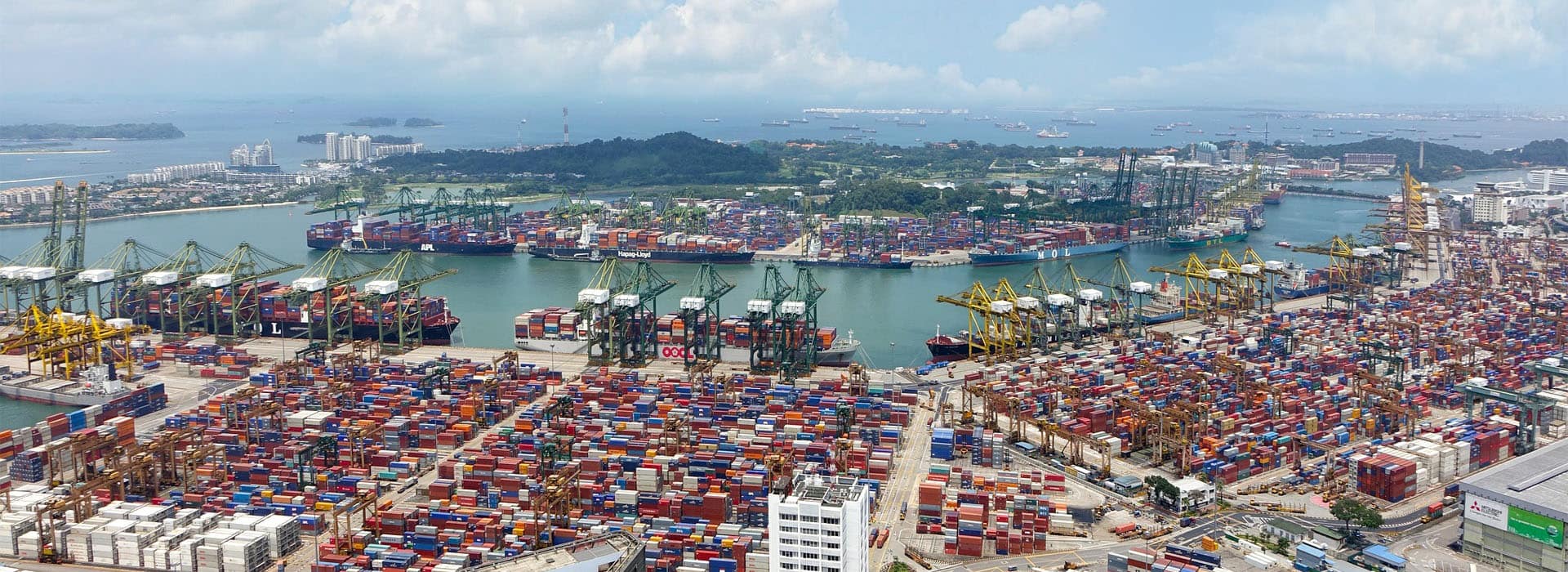 Vista aérea ampla de navio, berços e pátio de contêineres