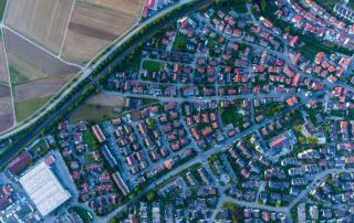 Uma cidade com muitas casas e estradas em seu centro, vista de cima, olhando para baixo em uma grande cidade com muitas casas e muita terra, (uma foto microscópica: 0,277).