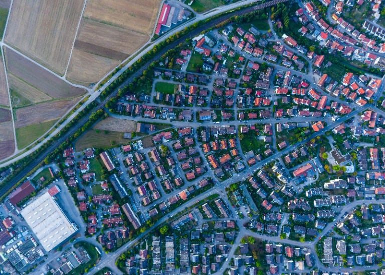 Uma cidade com muitas casas e estradas em seu centro, vista de cima, olhando para baixo em uma grande cidade com muitas casas e muita terra, (uma foto microscópica: 0,277).