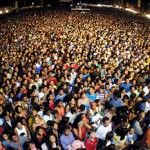 Uma grande multidão de pessoas está reunida à noite para um concerto em um estádio ou auditório com uma grande quantidade de pessoas. (Uma foto microscópica: 0,491)