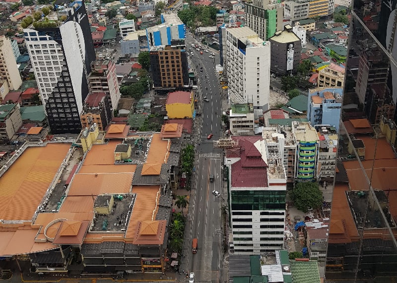 Uma cidade com muitos prédios altos e uma rua à frente com um arranha-céu acima dela e alguns prédios ao fundo, (uma foto com efeito de tilt shift: 0,566).