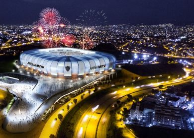 Um estádio com fogos de artifício no céu e um grande prédio com uma cúpula em cima à noite, com a linha do horizonte da cidade ao fundo. (uma representação digital: 0,660)