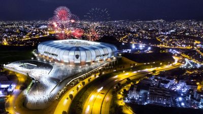 Um estádio com fogos de artifício no céu e um grande prédio com uma cúpula em cima à noite, com a linha do horizonte da cidade ao fundo. (uma representação digital: 0,660)