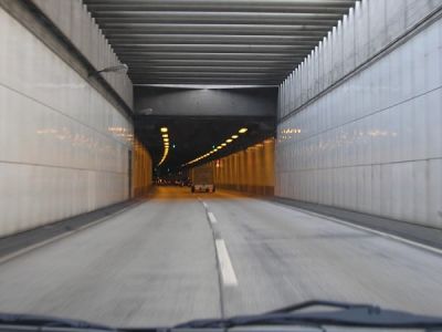 Um carro dirigindo através de um túnel com uma luz ao seu lado e outro carro dirigindo pelo túnel com uma luz ao seu lado (uma pintura fosca: 0,148).