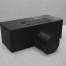 Uma caixa preta com uma tampa preta em uma superfície branca com um fundo branco e um objeto preto no meio da caixa com uma tampa preta, (uma renderização 3D:0,289)